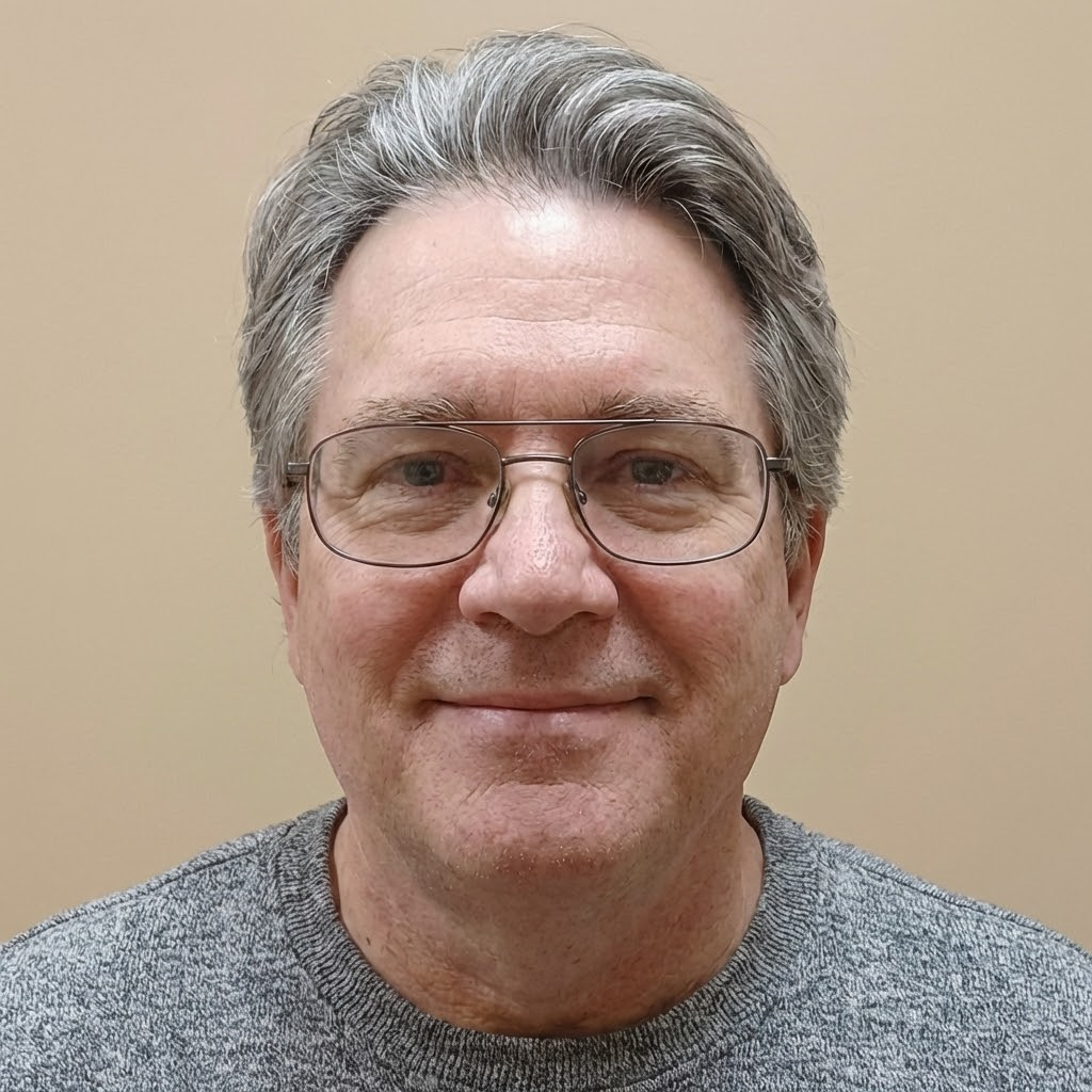 A circular portrait of a young woman with dark, wavy, shoulder-length hair looking at the camera.