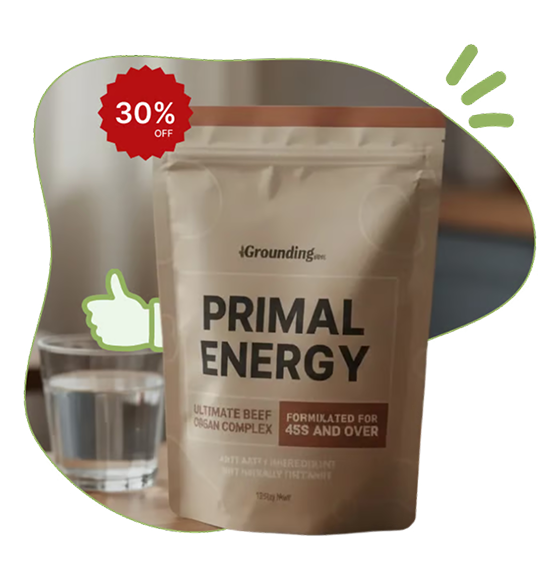 A pouch of Primal Health dietary supplement sits on a wooden table next to a glass of water.