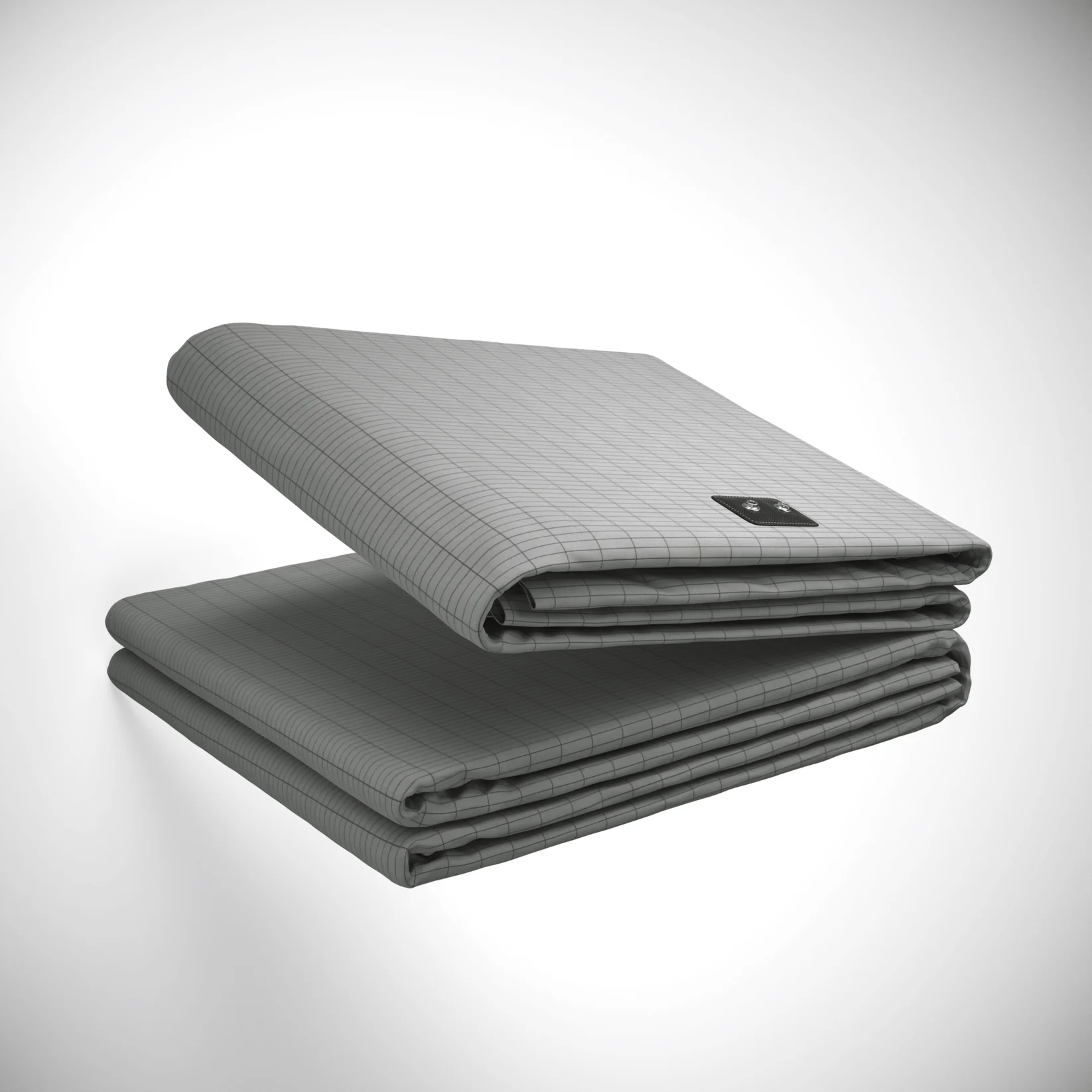 Folded gray mattress with grid pattern and small black label.