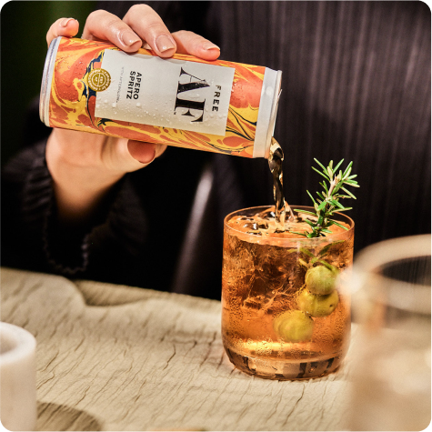 Pouring canned drink into a glass with garnish.