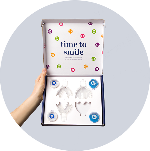 Hand holding a dental impression kit with colorful packaging.