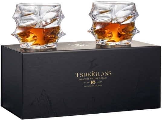 Two whiskey glasses with amber liquid on a box labeled 'Tsukiglass Japanese Whiskey Glass'.