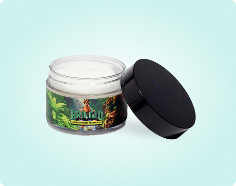 Open jar of cream with a black lid on the side, label featuring green imagery.