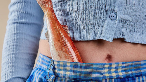 Person with fish in waistband of blue plaid pants.