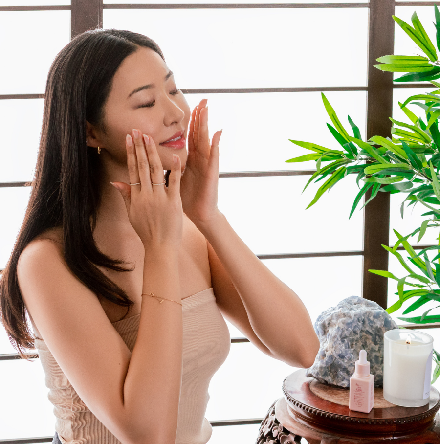 Person holding a bottle of 'rhode' skincare product near their face.