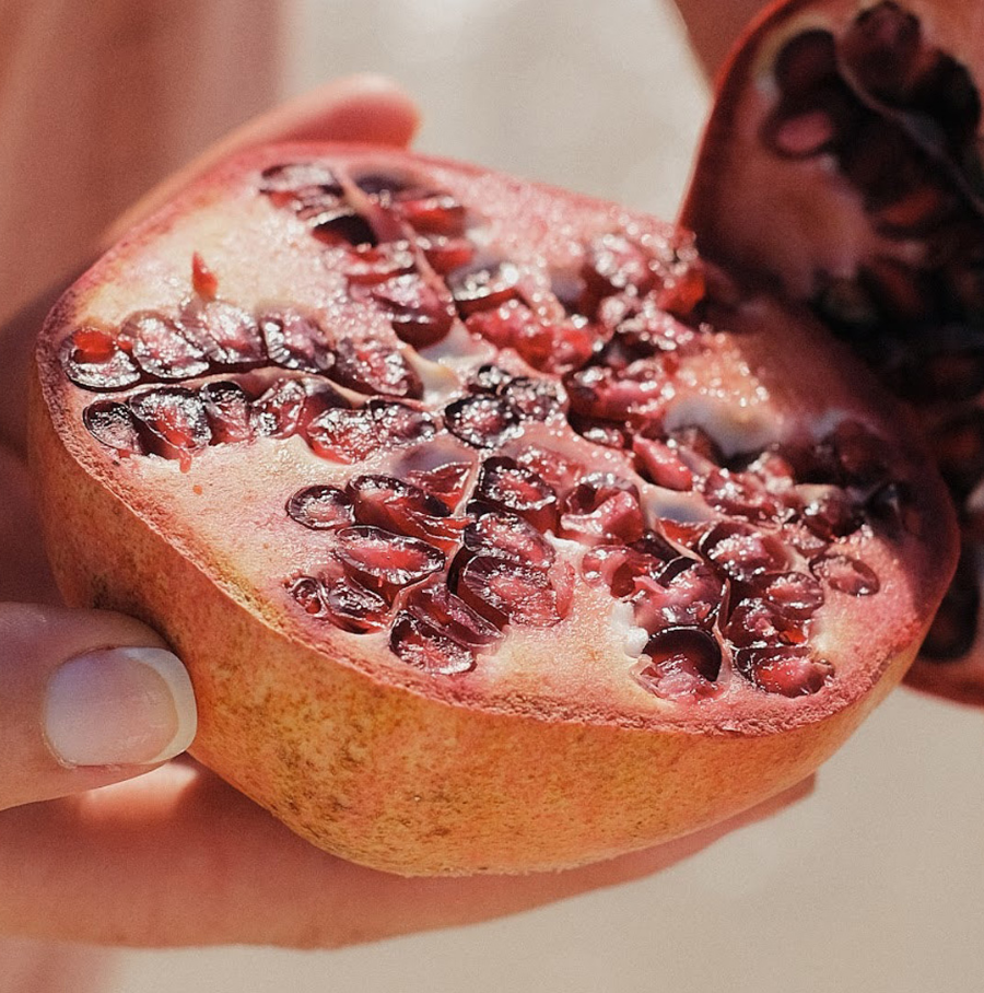 Person applying cream to face, holding a skincare product.