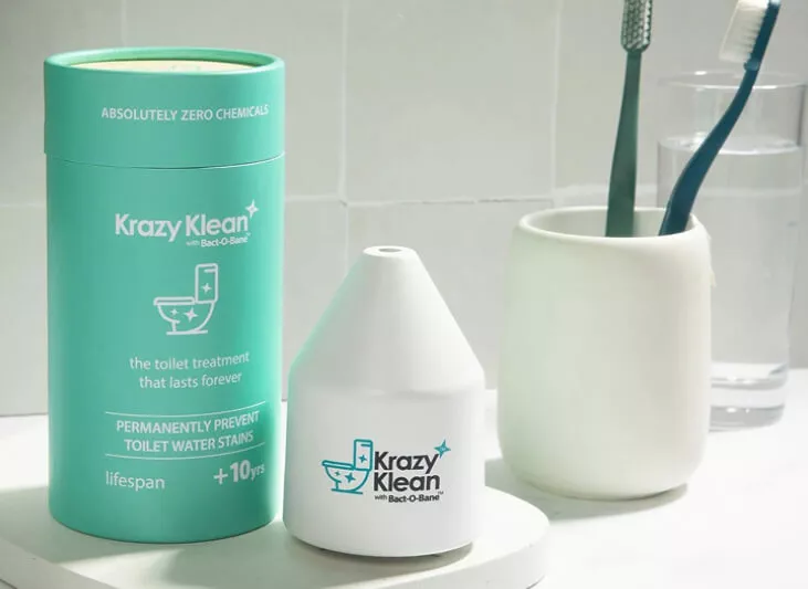 Krazy Klean toilet treatment product and packaging on a bathroom counter next to a toothbrush holder.