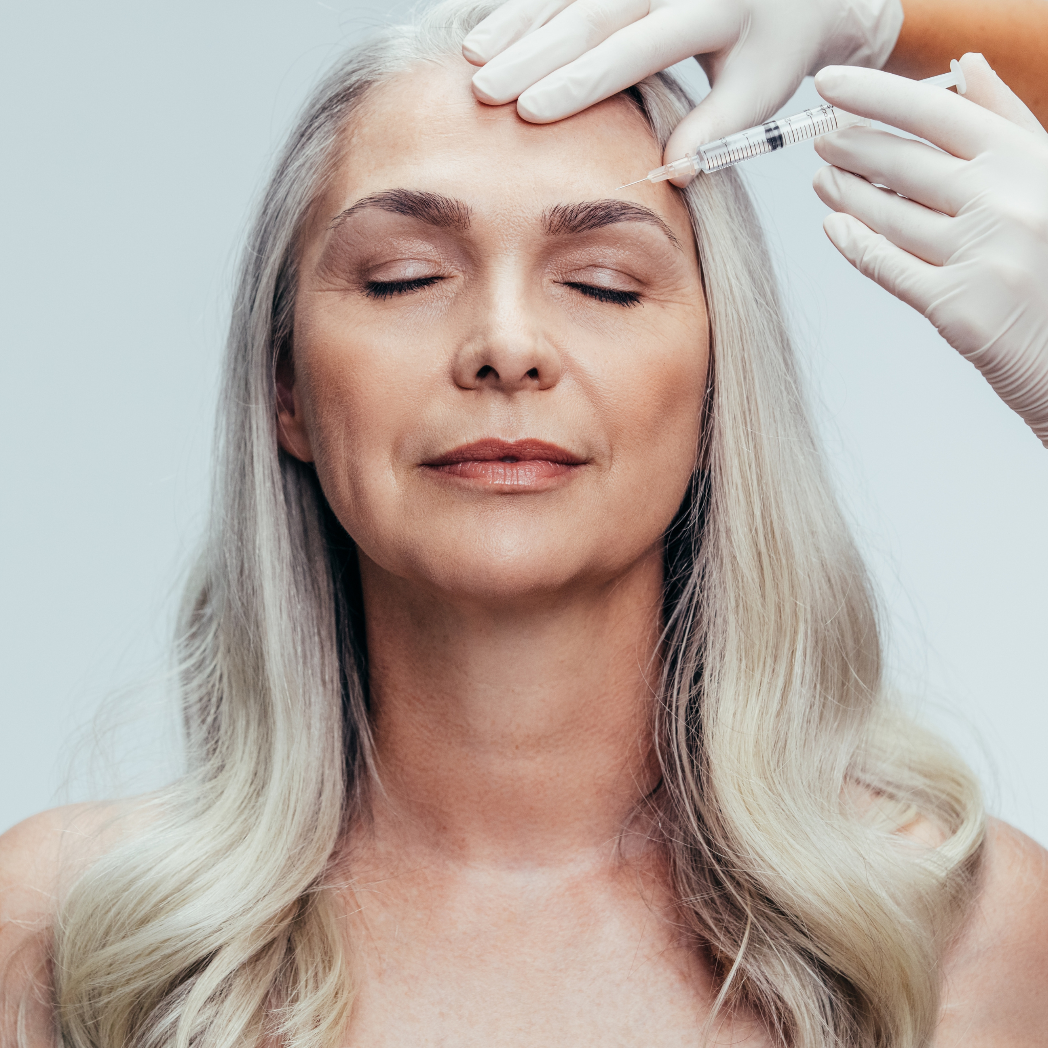 Person receiving a cosmetic injection on forehead.