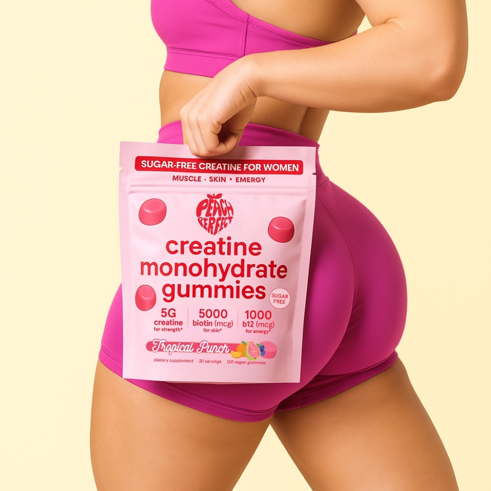 Pink creatine gummies package held by person in purple workout attire.