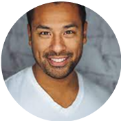 Smiling person in a white shirt against a gray background.