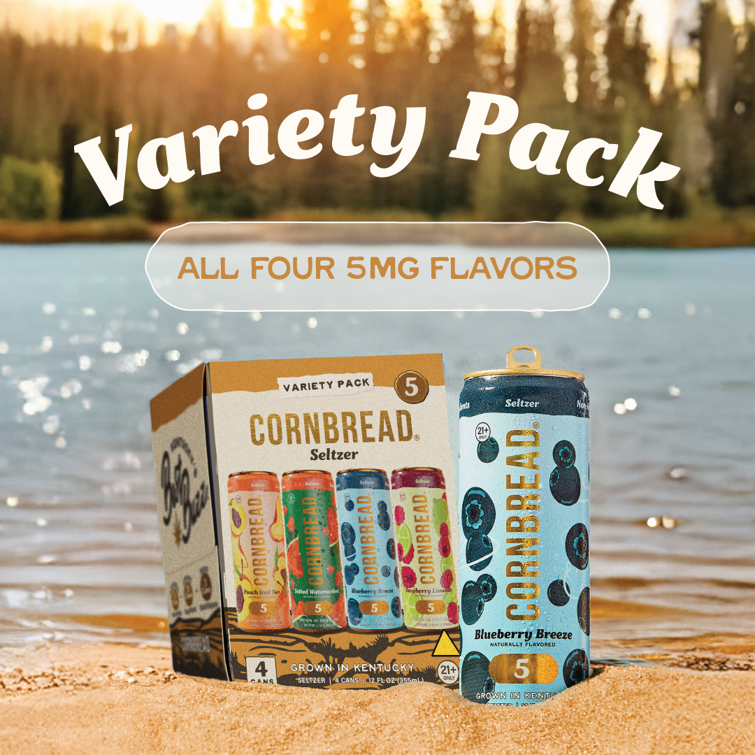 Variety pack of Cornbread seltzer cans by a lake with trees.