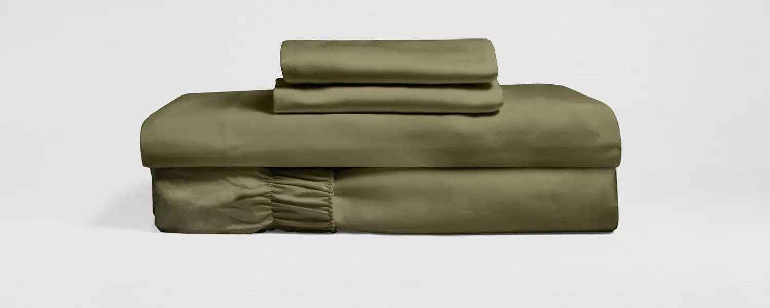 Stack of olive-green bed sheets and pillowcases.
