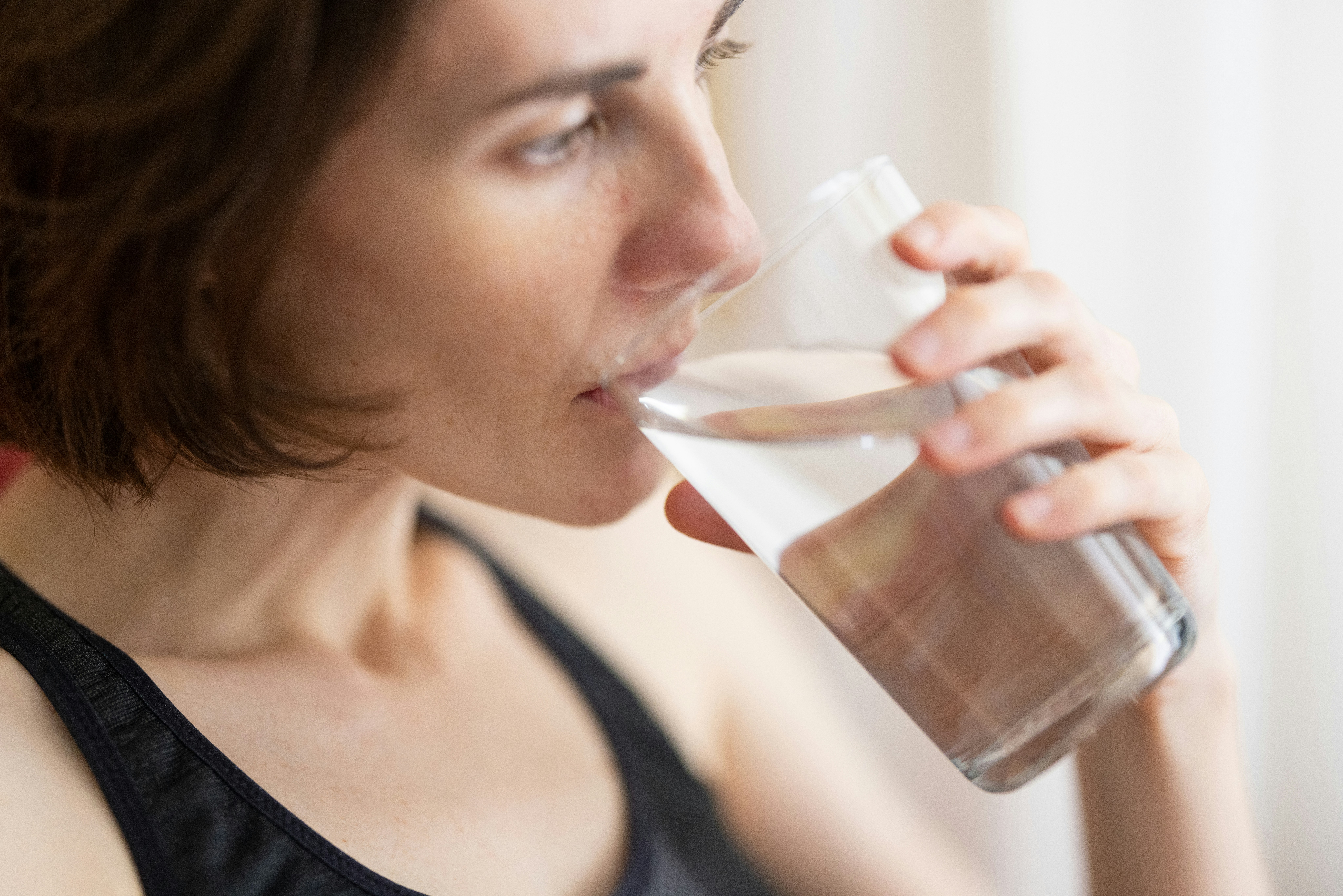 A person drinking a glass of water.