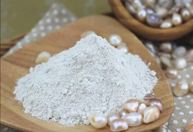 A wooden plate with white powder and scattered pearls.