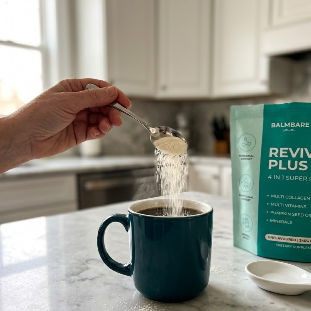 A hand pours a spoonful of powder into a steaming mug of coffee in a kitchen.