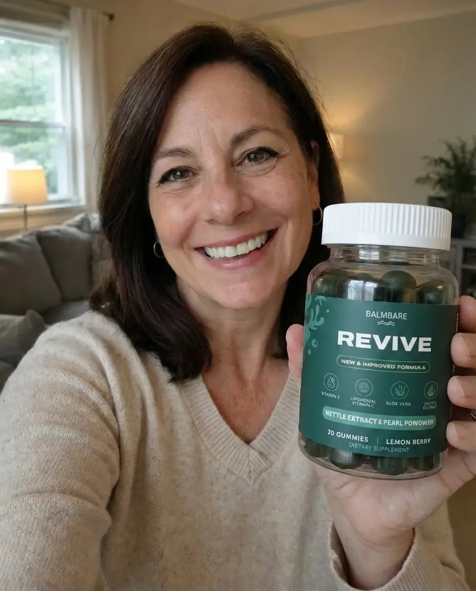 A smiling woman in a cream sweater holds up a bottle of Balmbare Revive lemon berry gummies.