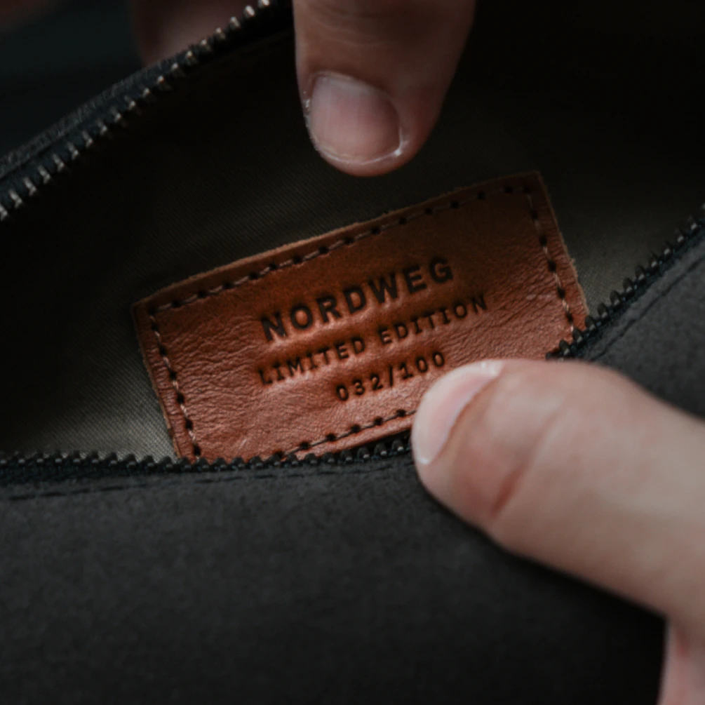 Dedo aponta a etiqueta de couro com a numeração 032/100 no interior da Sling Bag Pulse Limited Edition Nordweg