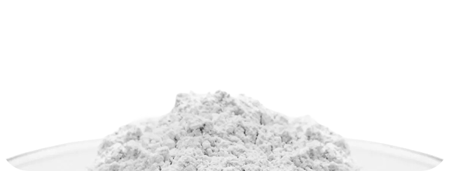 A mound of white powder on a clear dish against a white background.