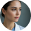 Portrait of a person with dark hair, wearing a white coat, looking to the side.