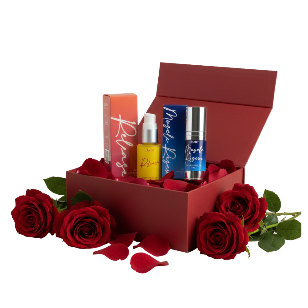 A red gift box with two cosmetic products inside, surrounded by red roses and petals.