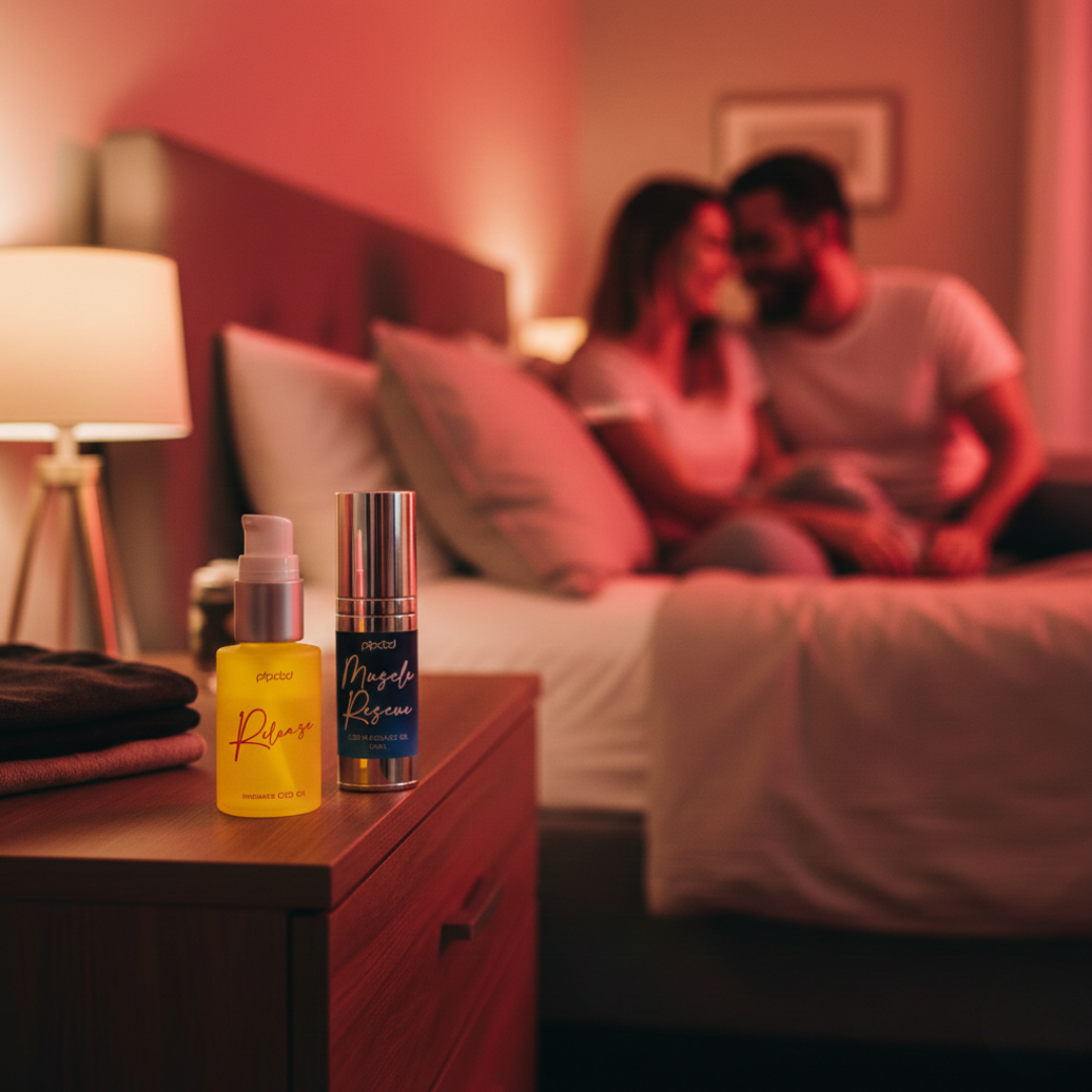 Two product bottles on a nightstand, with a couple out of focus on a bed in the background.