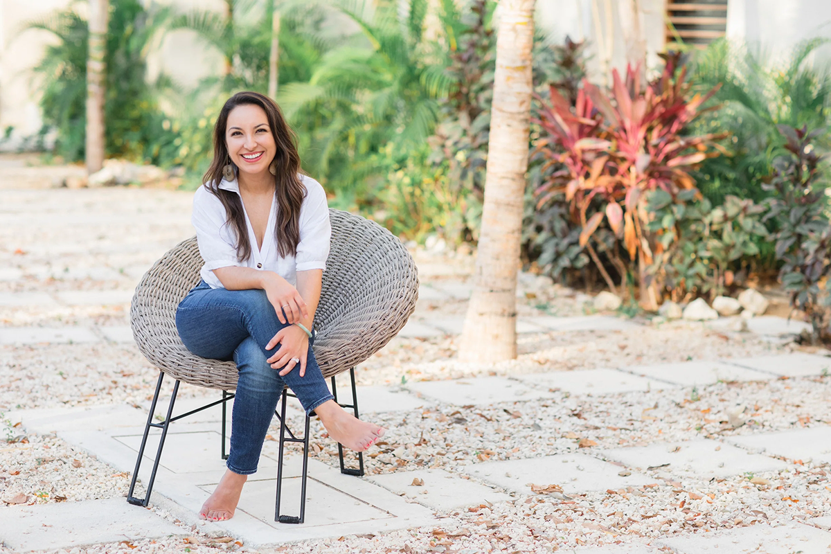 Rebecca Alvarez Story sitting outdoors, smiling