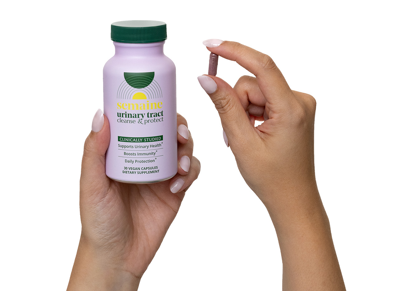 Hand holding a supplement bottle and capsule for urinary tract health.
