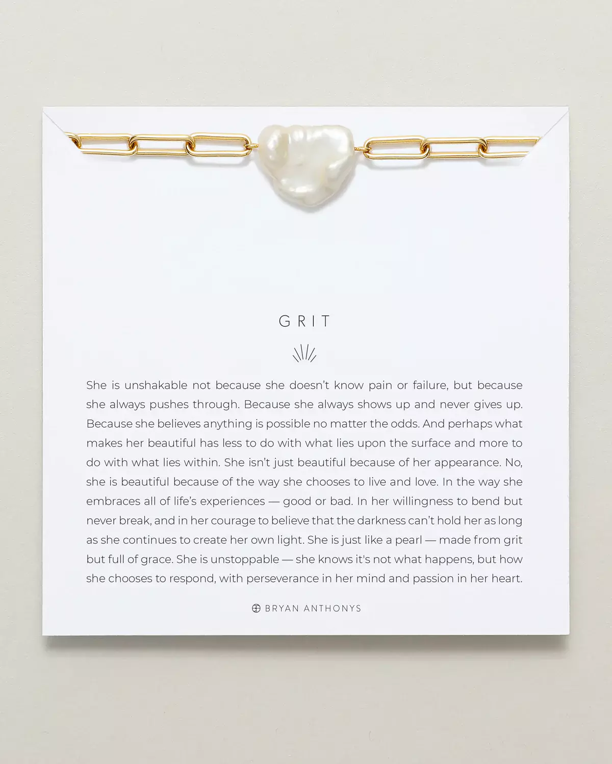 A gold chain necklace with a charm featuring three rectangular, clear baguette stones set closely together, is displayed on a white card. The card features the title 'BEAUTIFULLY BROKEN'A gold chain necklace with a charm featuring three rectangular, clear baguette stones set closely together, is displayed on a white card. The card features the title 'BEAUTIFULLY BROKEN'.