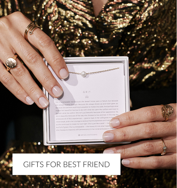 A close-up of a person's hands holding an open white jewelry box, which contains a delicate gold necklace featuring a single pearl. The inside of the box lid has a printed description for the 'Grit' necklace. A white overlay text at the bottom reads, 'GIFTS FOR BEST FRIEND.'