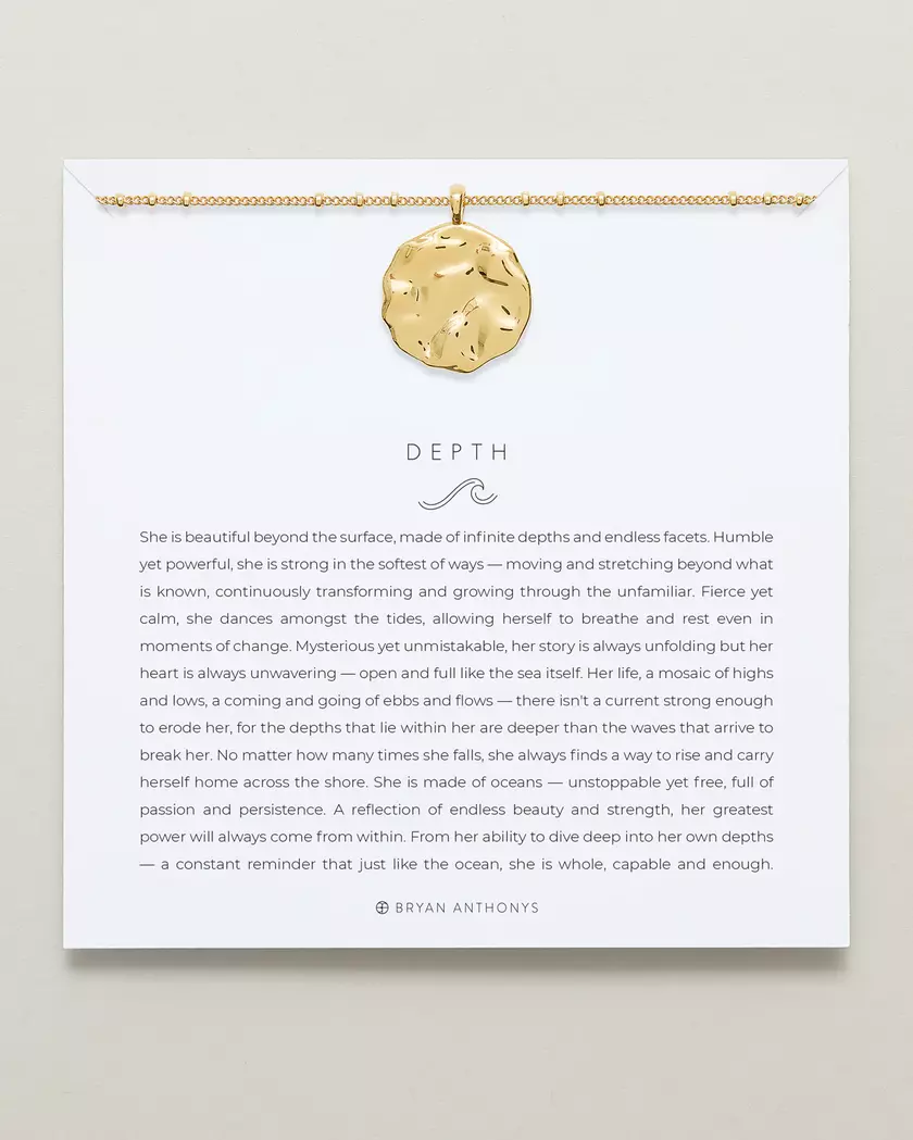 A gold chain necklace with a large, organically shaped, hammered gold pendant is displayed on a white card. The card features the title 'DEPTH'.