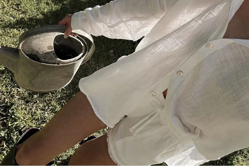 Girl wearing linen clothes holding a watering can