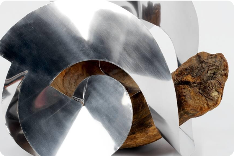 Abstract sculpture with shiny metal and wood elements.