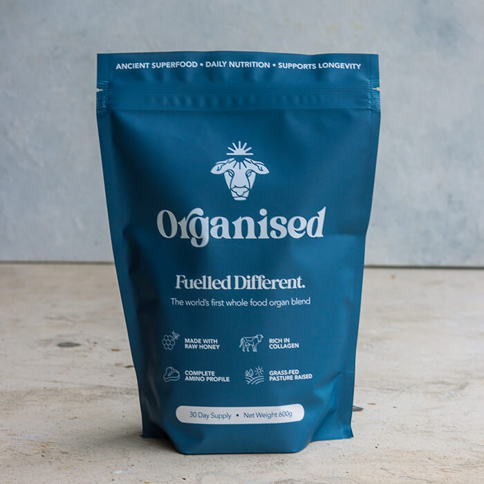 Blue package of Organised whole food organ blend on a gray background.