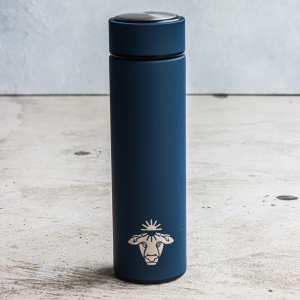Blue insulated bottle with sheep logo on a concrete surface.