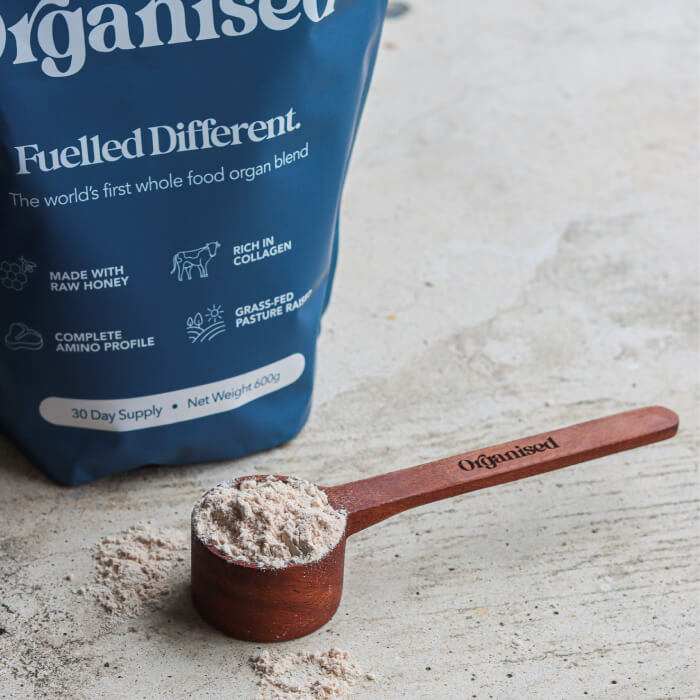 Scoop of powder next to a blue bag with product information.