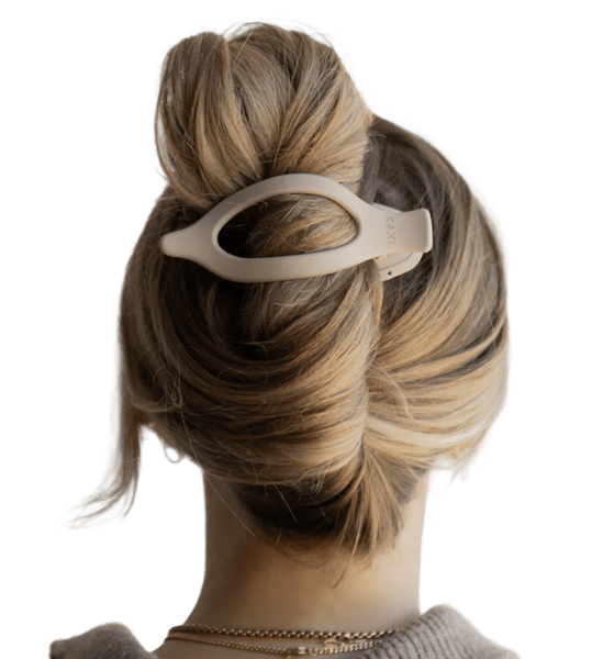 Back view of a woman with a hair clip holding a bun.