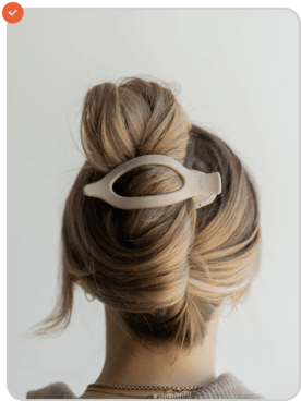 Back view of a woman with a bun secured by a large hair clip.