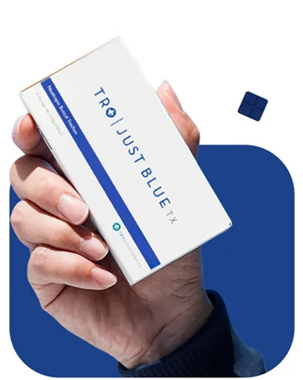 A person's hand holding a white and blue box labeled 'TRO | JUST BLUE TX' against a blue background.