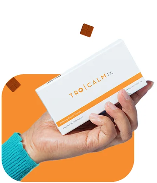 A hand in a teal sweater holds a white and orange box of TRO CALM TX.