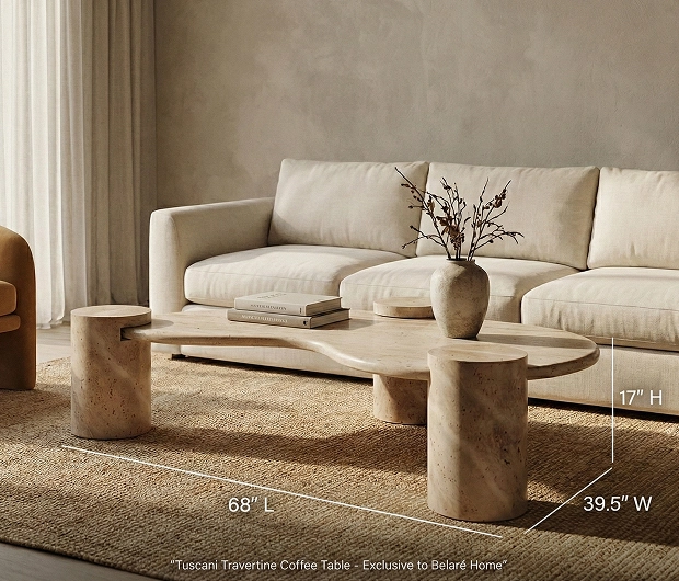 An organically shaped travertine coffee table sits in front of a light-colored sofa on a jute rug.