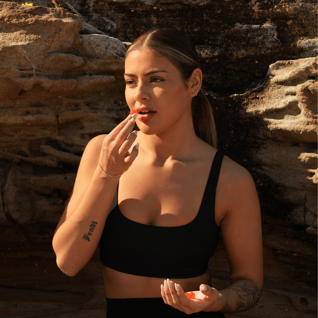 Person in athletic wear holding a medicine ball on a sports court.