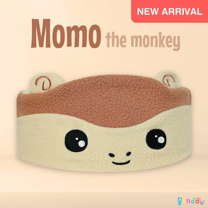 Cartoon monkey headband with cute face, labeled 'Momo the Monkey', marked as 'New Arrival'.