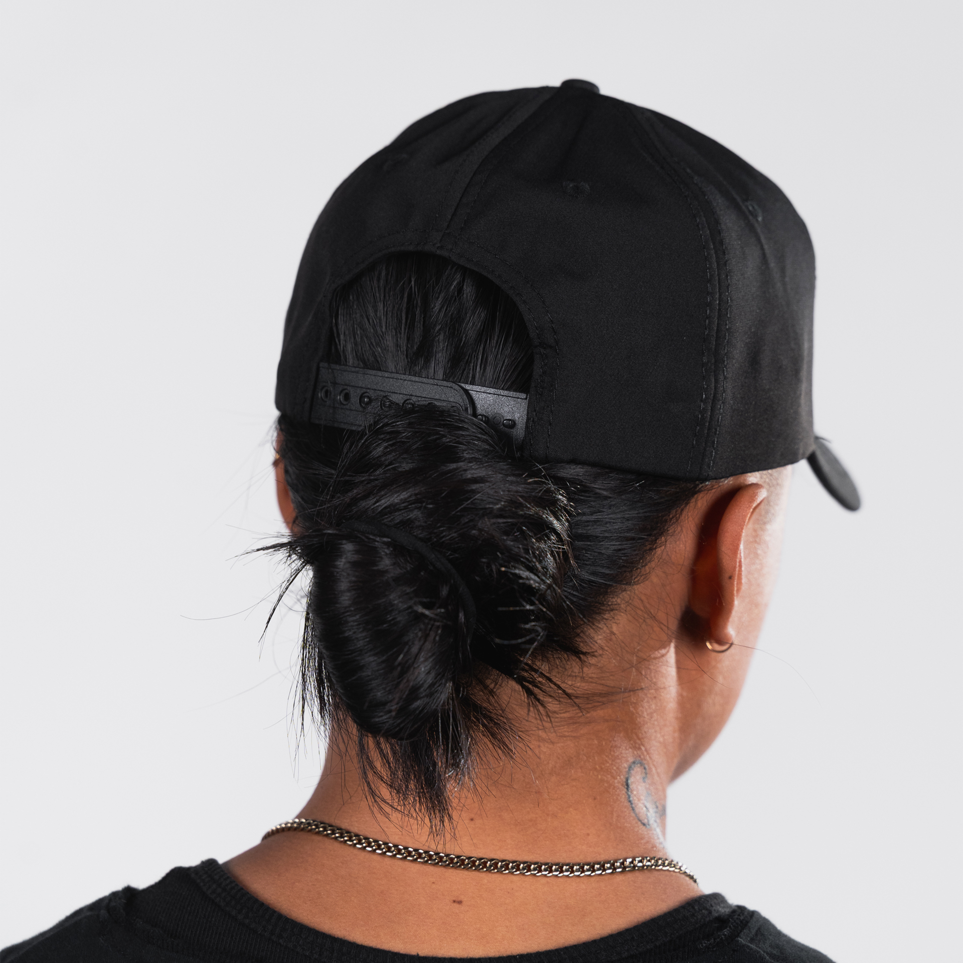 Person wearing a black cap, viewed from behind.