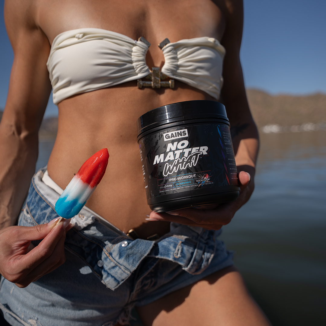 Person holding a popsicle and a container labeled 'No Matter What' by a lake.