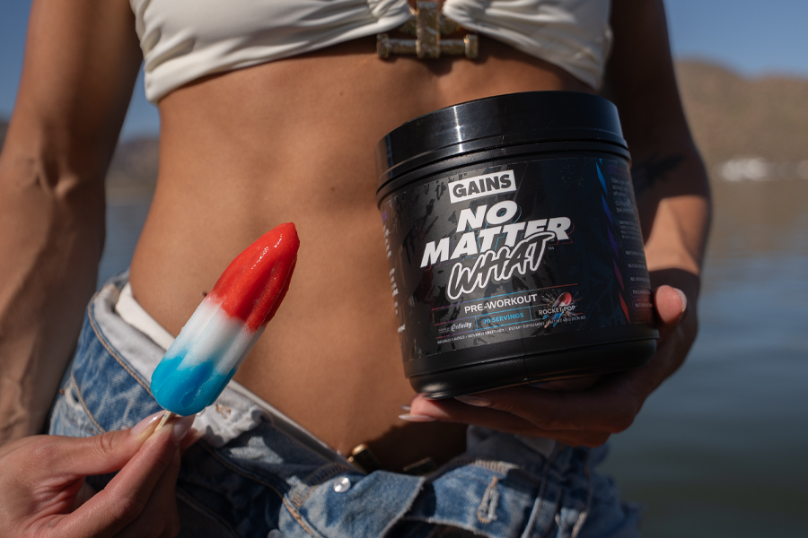 Person holding a red, white, and blue popsicle and a pre-workout supplement container.