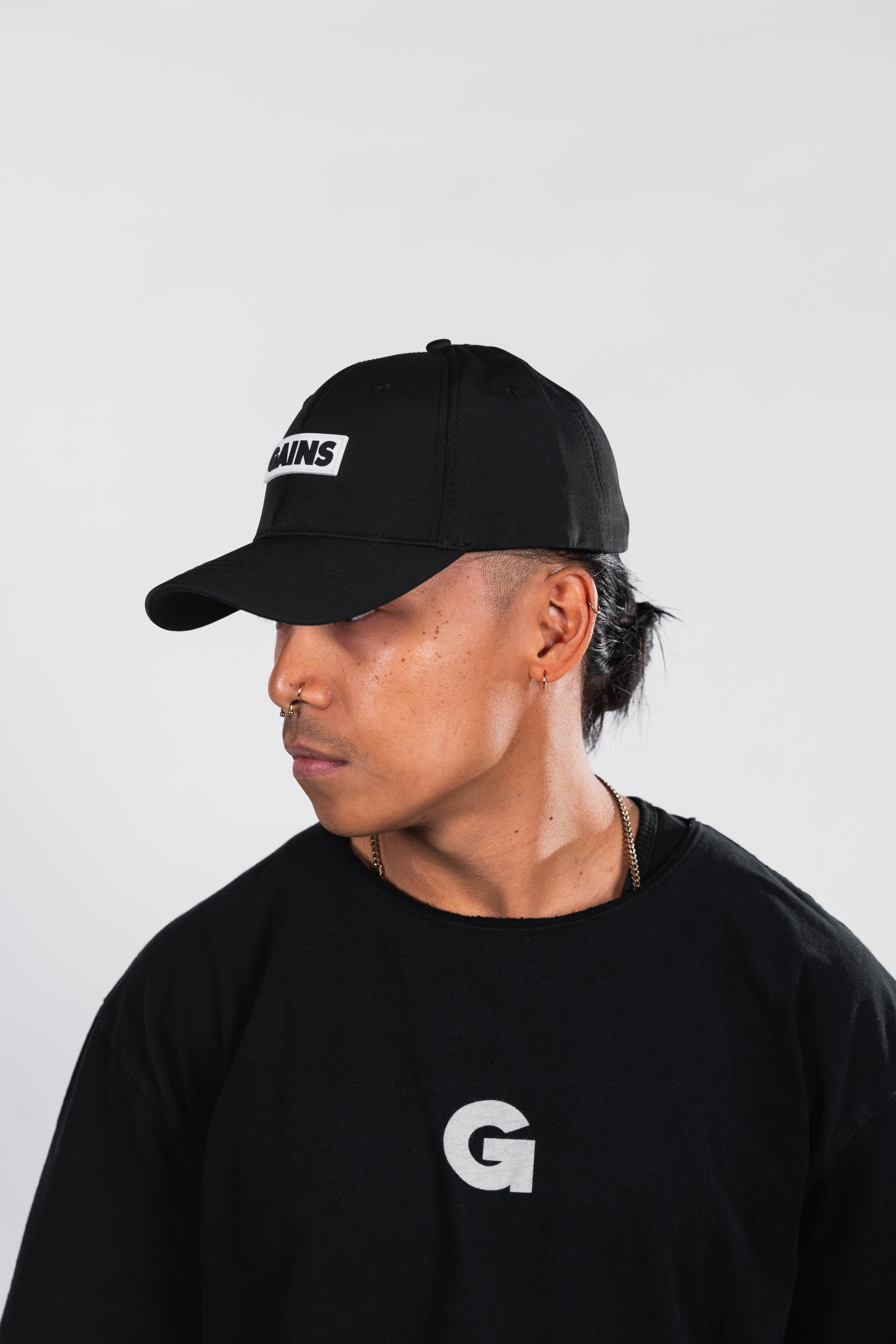 Person wearing a black cap and shirt with a letter 'G'.