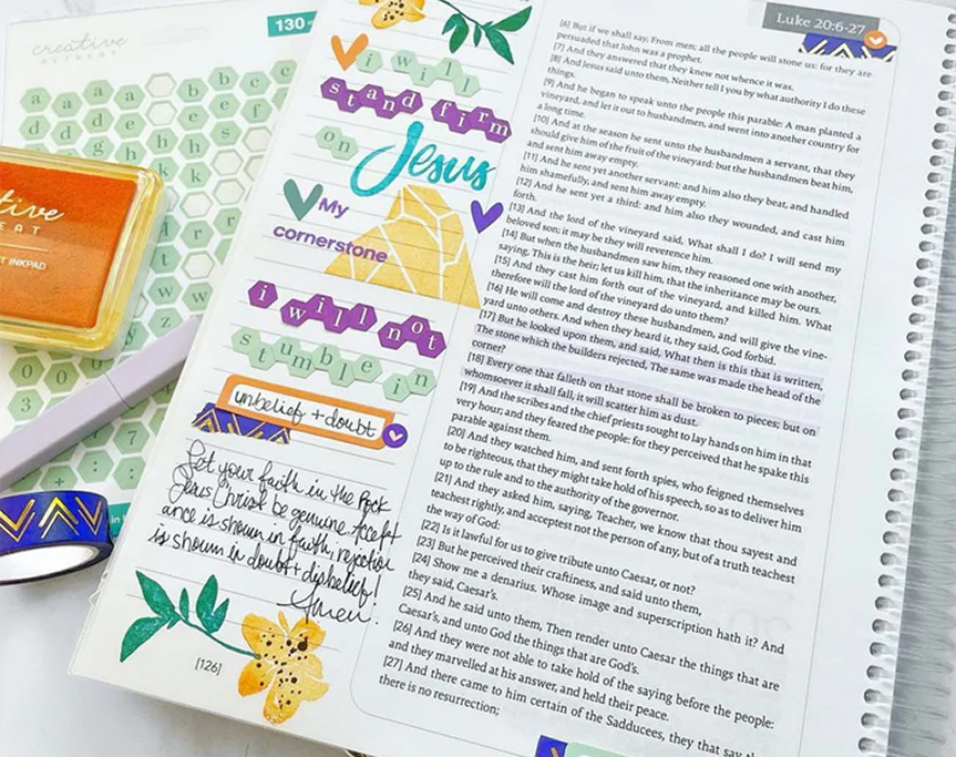 Decorated religious text page with colorful stickers and handwritten notes.