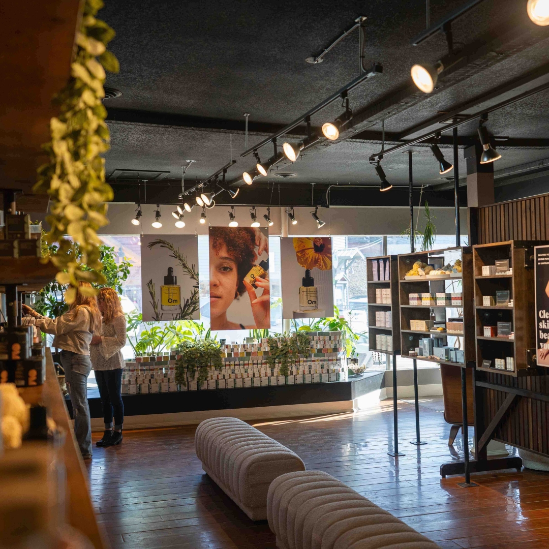 Interior of a modern store with plants, shelves, and product posters.