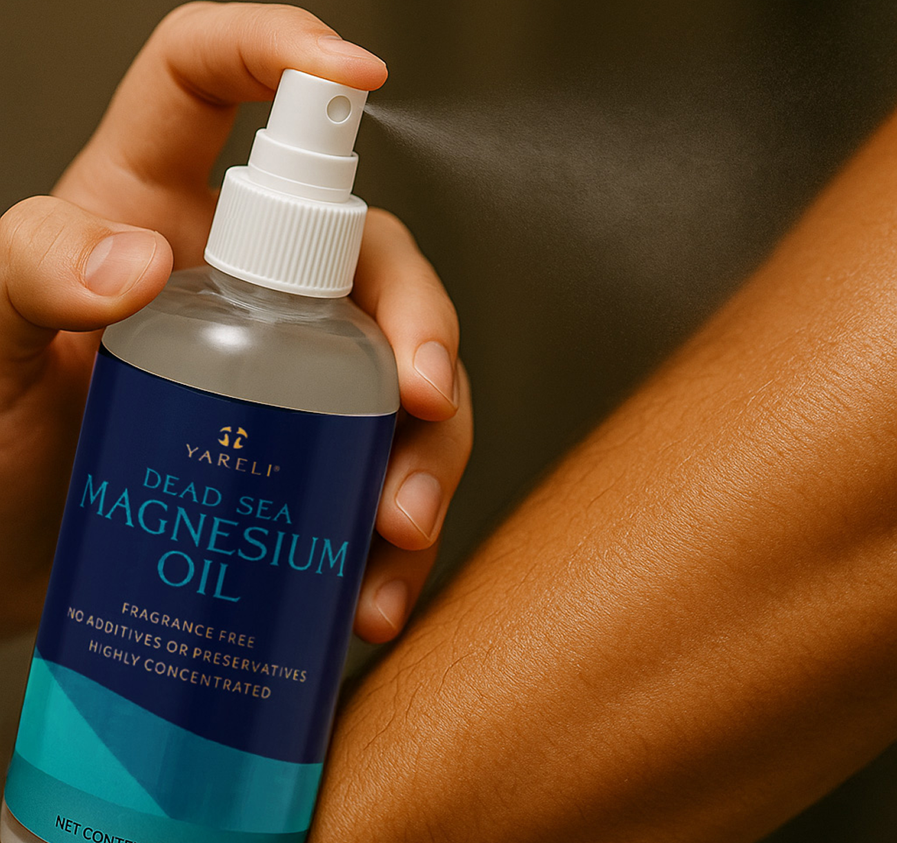 A hand sprays Dead Sea Magnesium Oil onto a forearm.