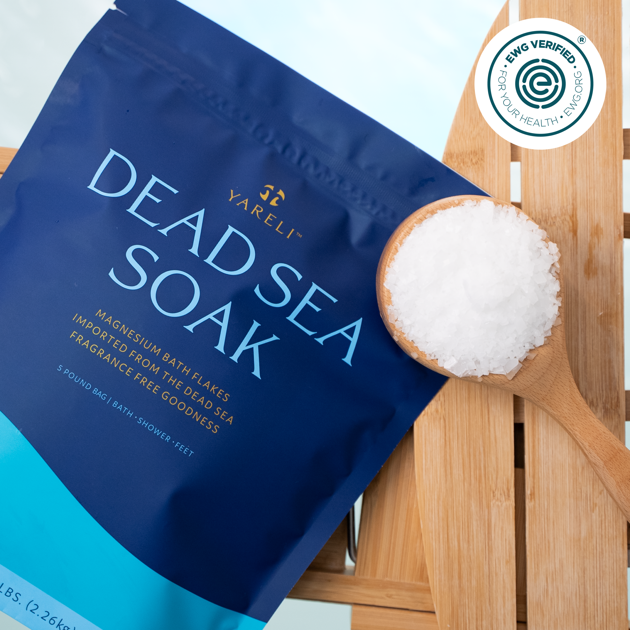 Package of Dead Sea magnesium bath flakes with a wooden scoop.